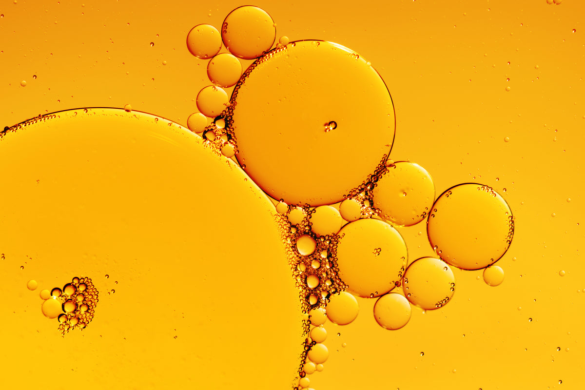 Golden oil droplets in amber liquid - Napa Fragrance