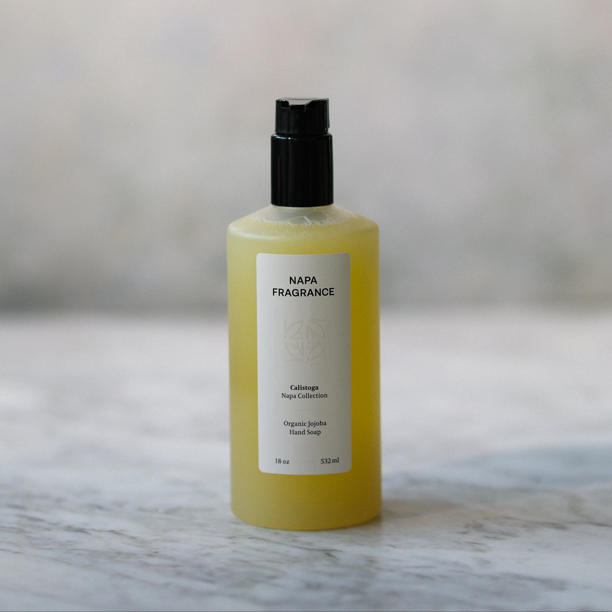 Yellow bottle with black cap on a marble surface