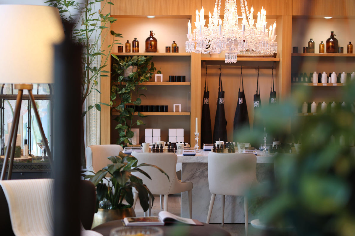 Modern interior with a chandelier, shelves with bottles, and a dining table.