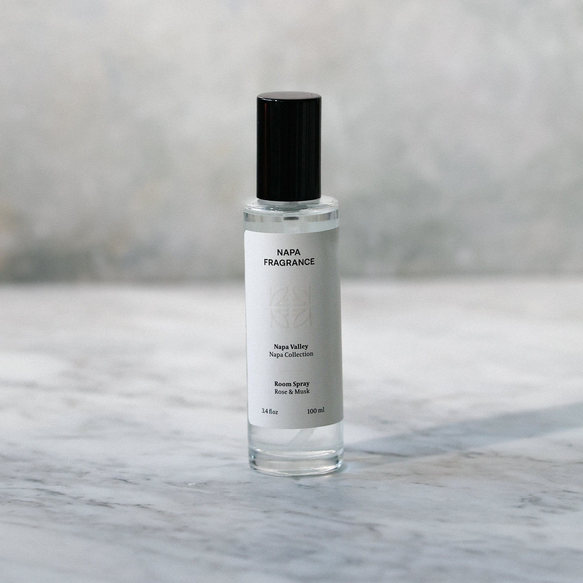 Small perfume bottle on a marble surface with a neutral background