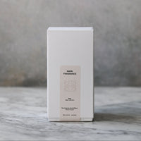 White box with a beige label on a marble surface with a gray background