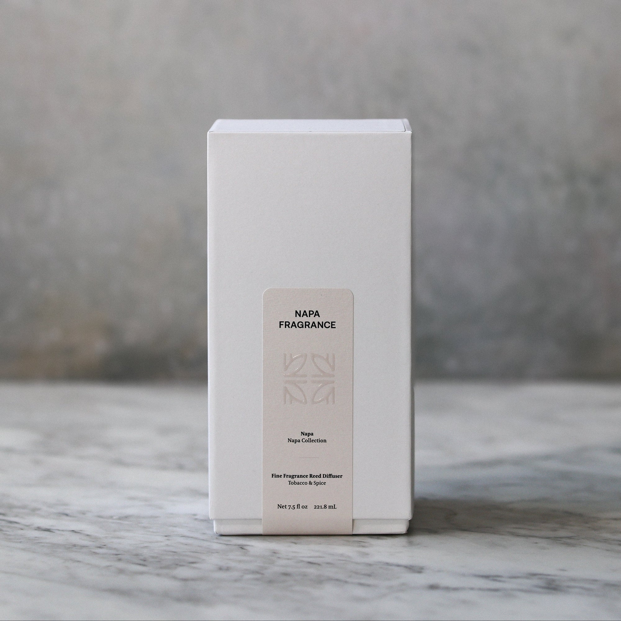 White box with a beige label on a marble surface with a gray background