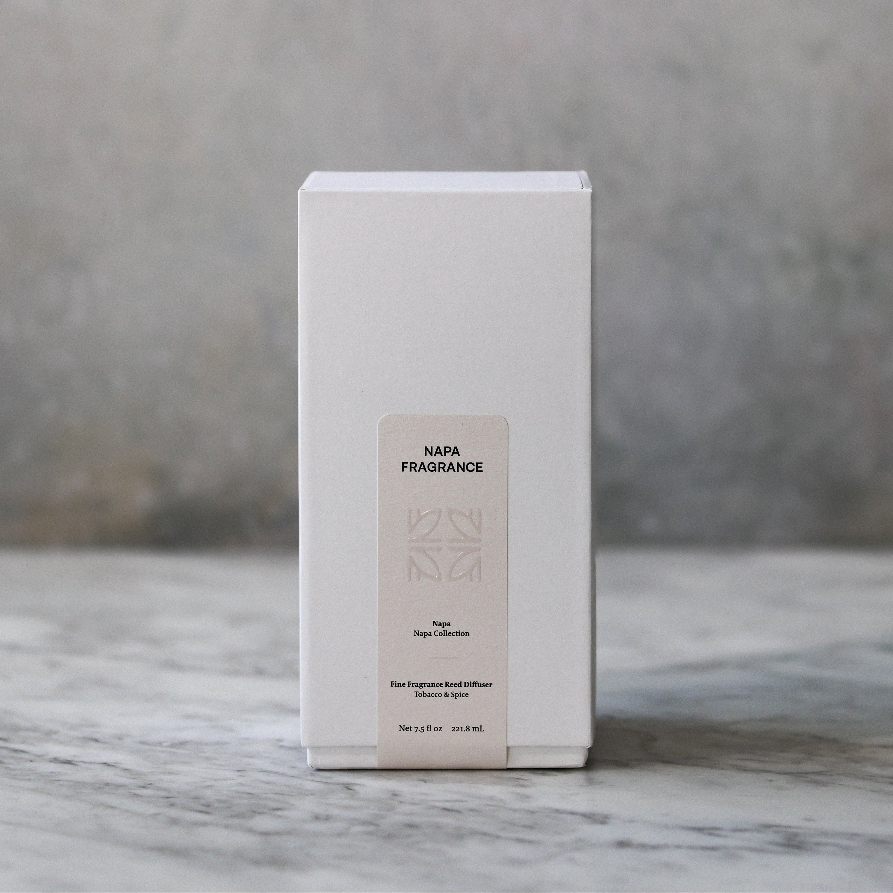 White box with a beige label on a marble surface with a gray background