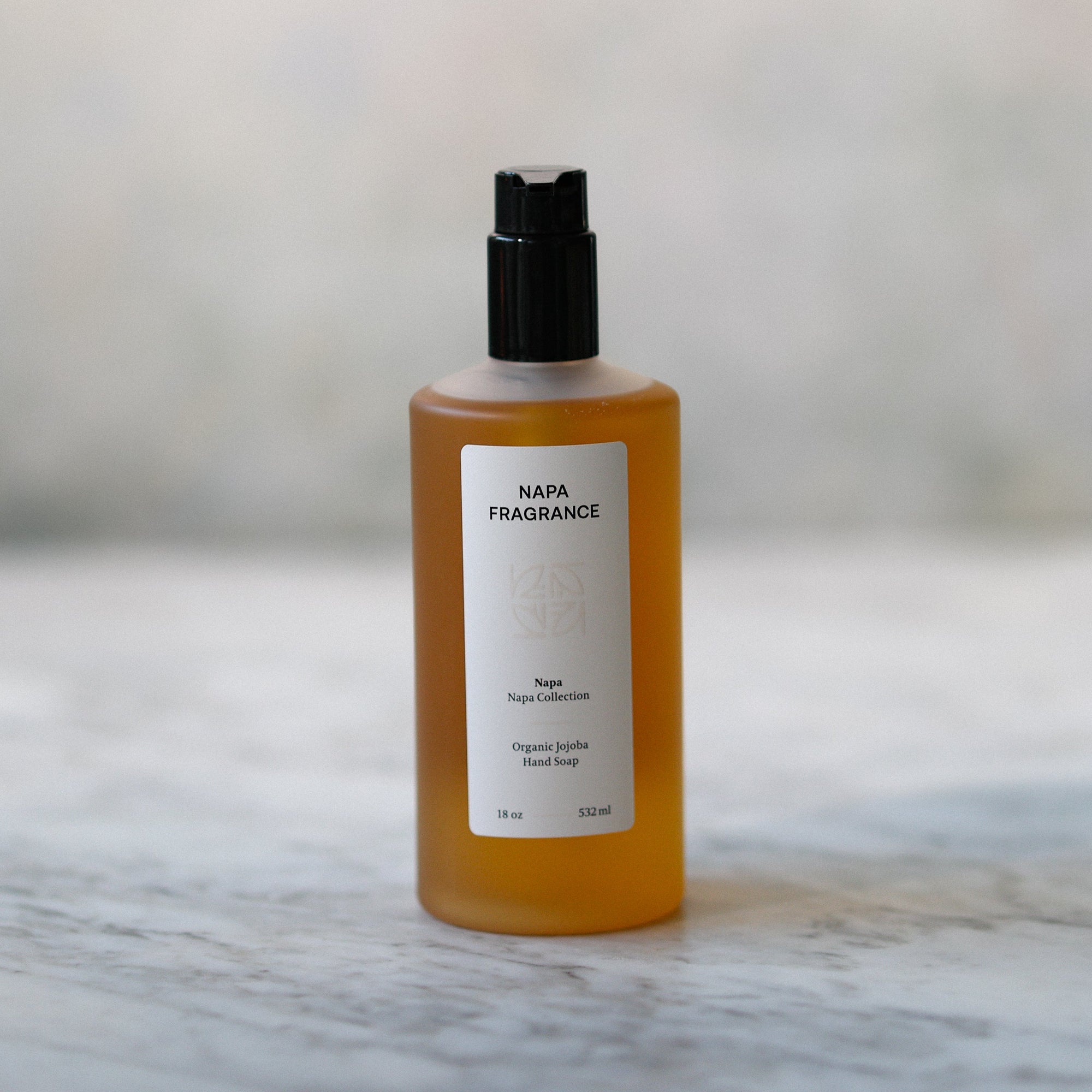 Bottle of Napa Fragrance on a marble surface with a blurred background