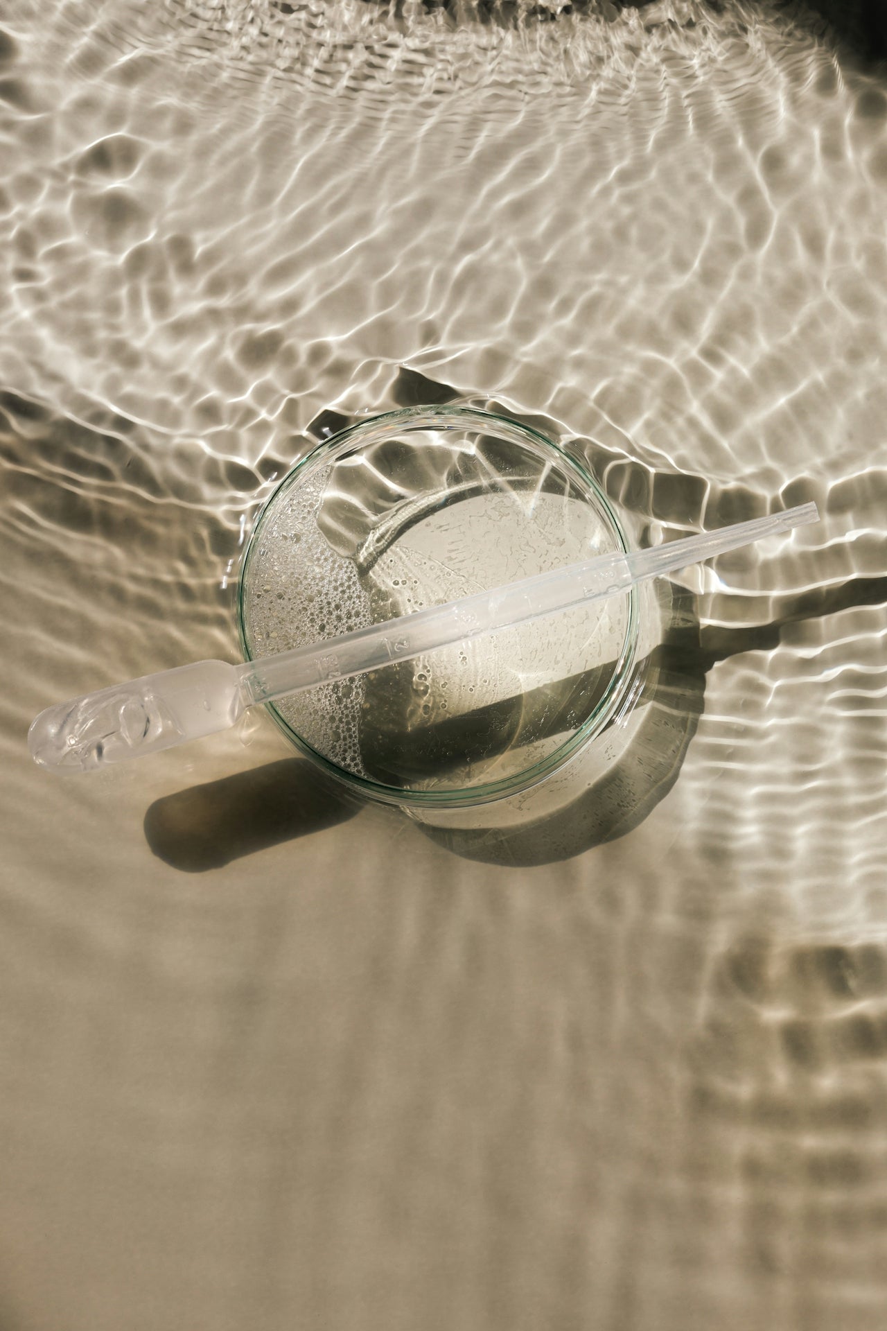 Clear glass with a straw floating on water