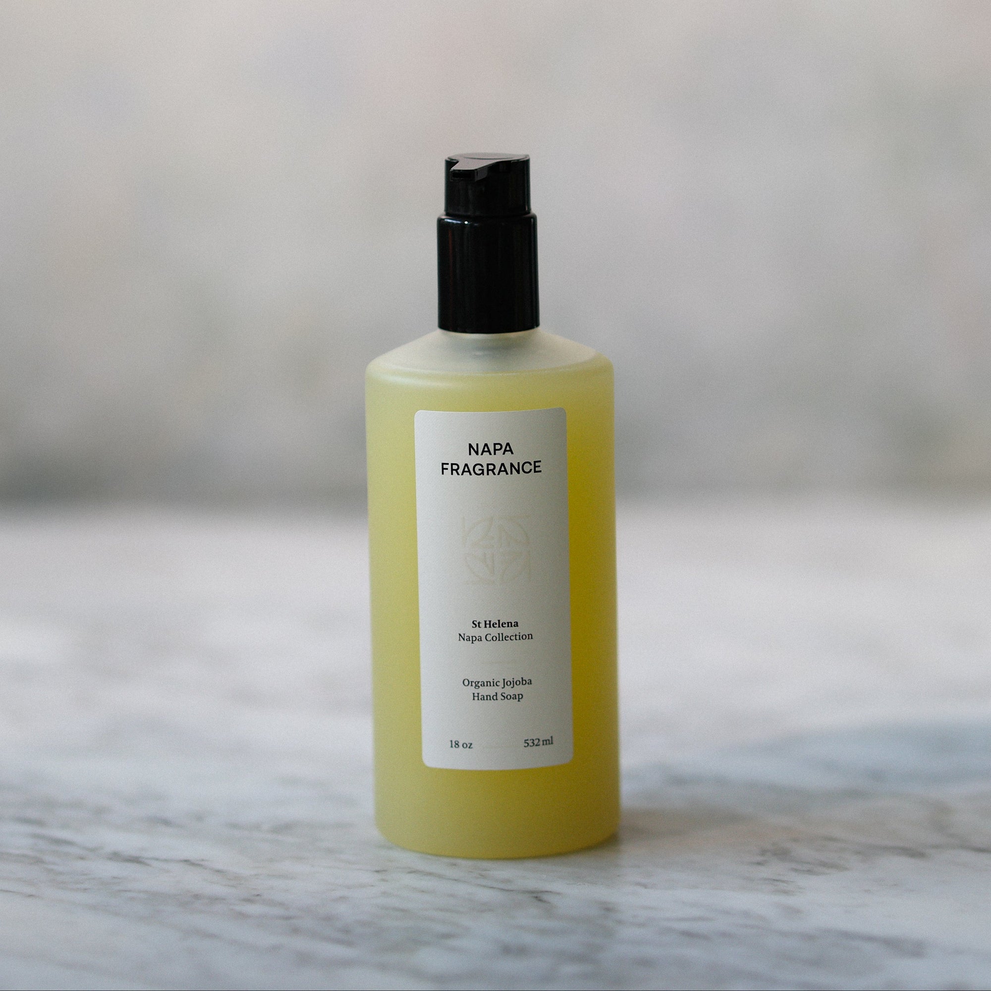 Yellow bottle with black cap on a marble surface
