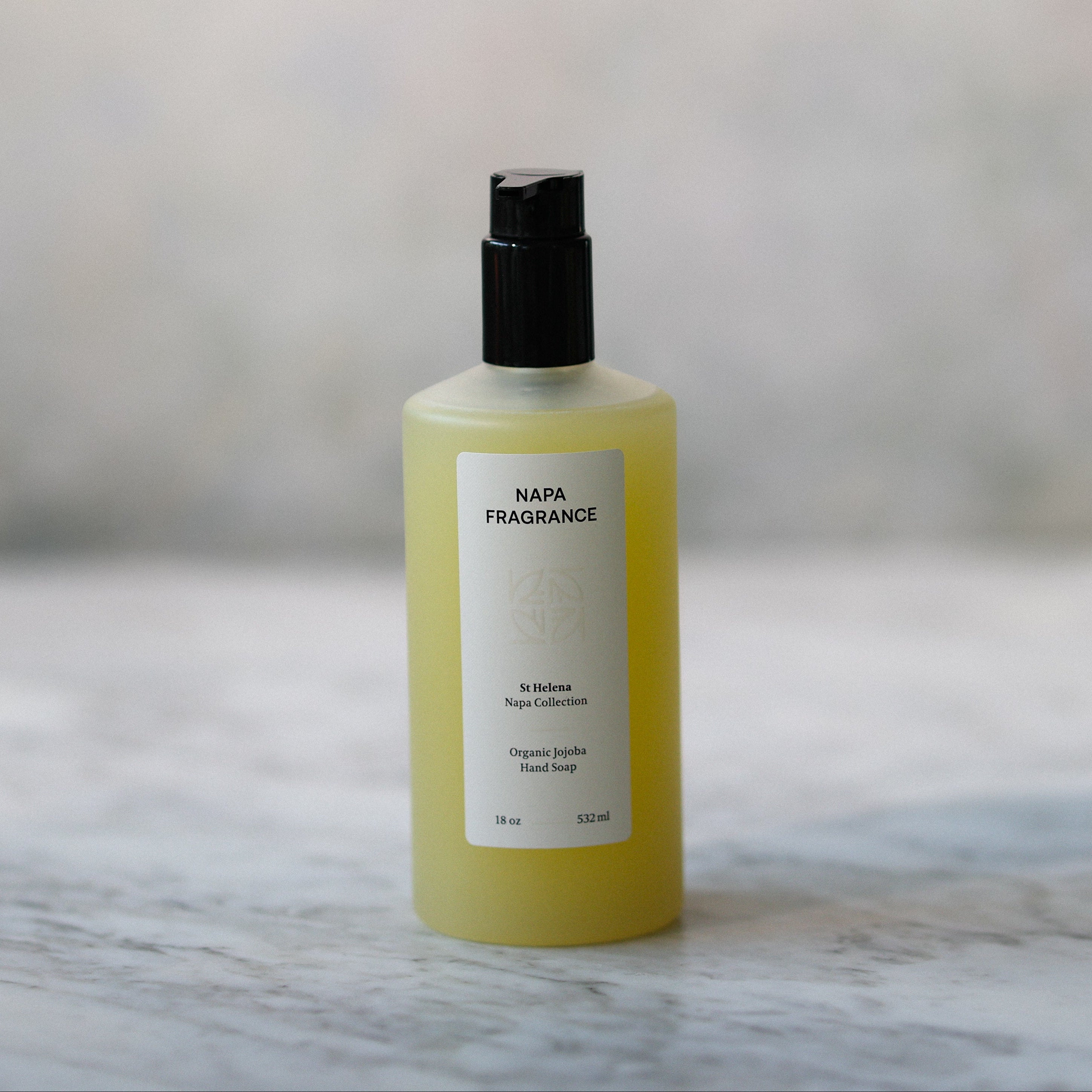 Yellow bottle with black cap on a marble surface