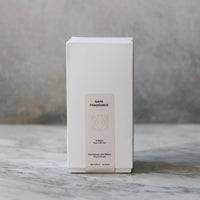White rectangular box with text on a marble surface and gray background