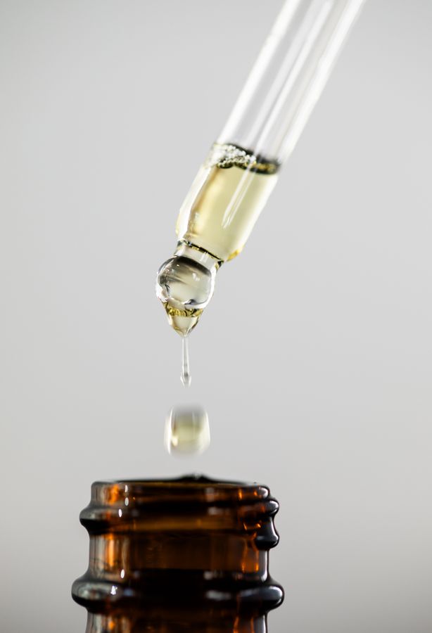 Glass dropper dispensing fragrance oil into amber bottle - Napa Fragrance